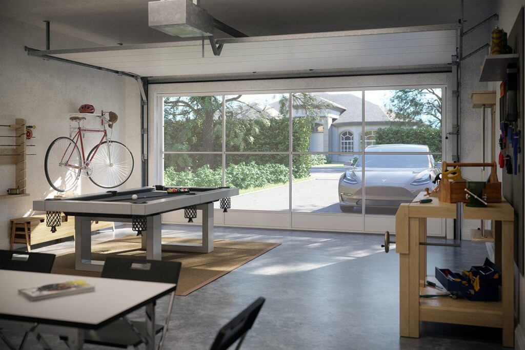 Interior of a garage with screen doors looking out towards a driveway with a car
